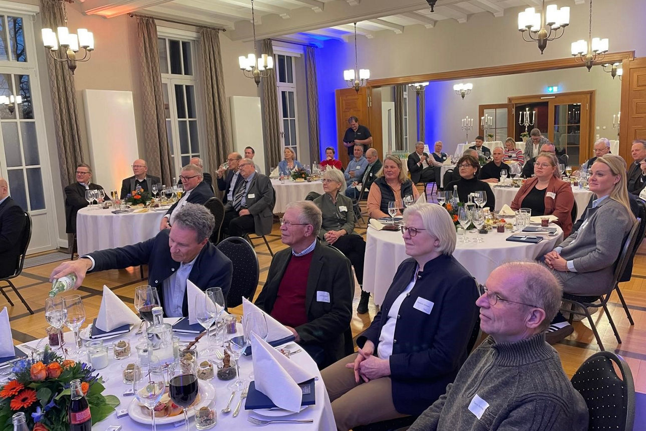 Viele Menschen, sitzend, in einem großen Saal.