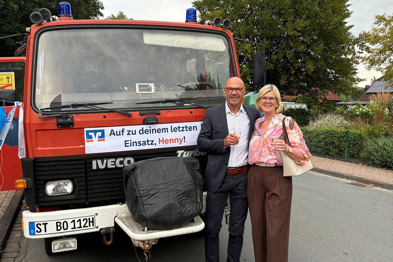 Foto von Henrike Hengstermann und einem Vorstandsmitglied vor einem Feuerwehrauto.