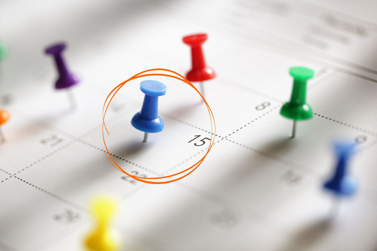 Kalender mit Pinnadeln und einem umkreisten Tag