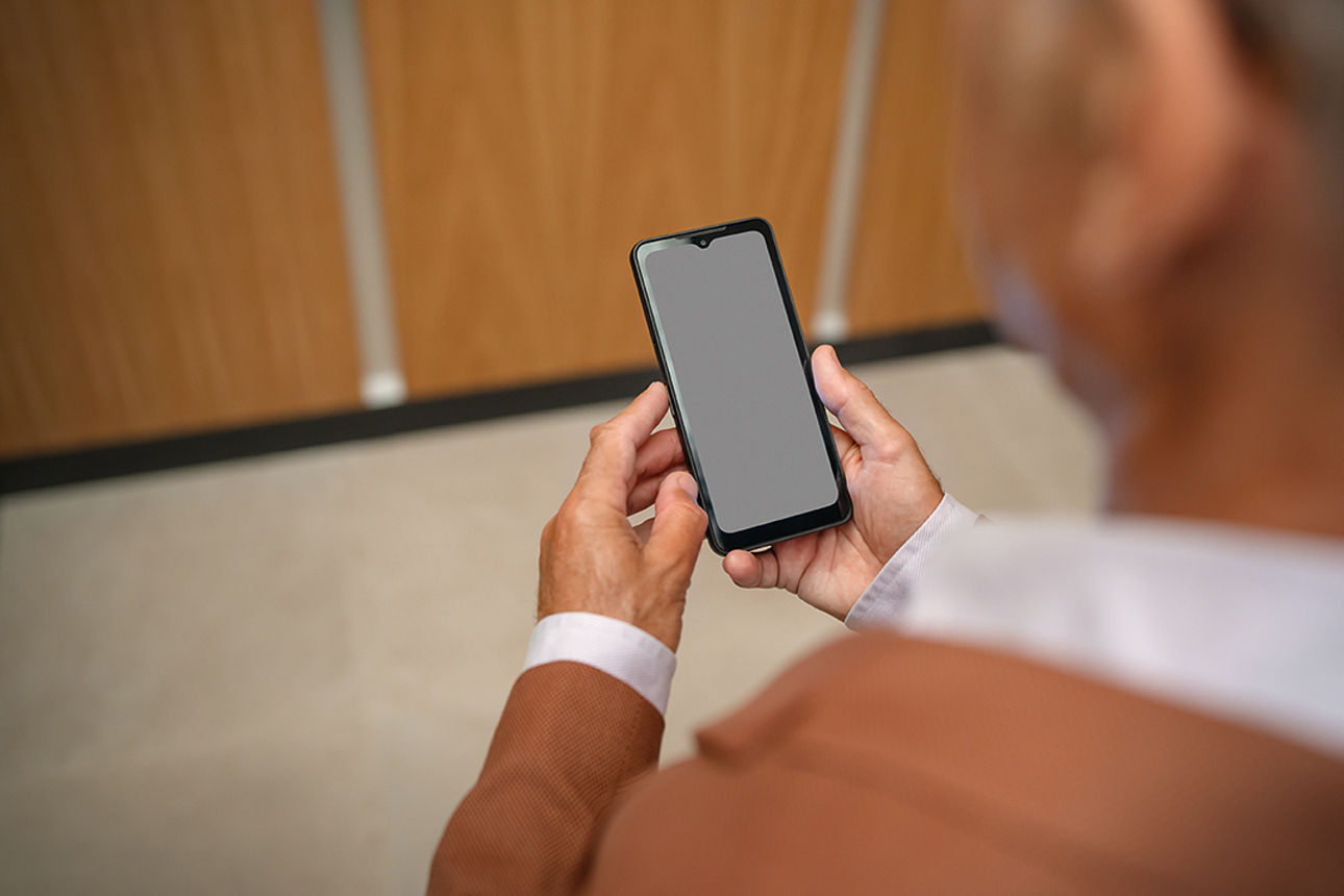 Mann schaut auf ein Smartphone.
