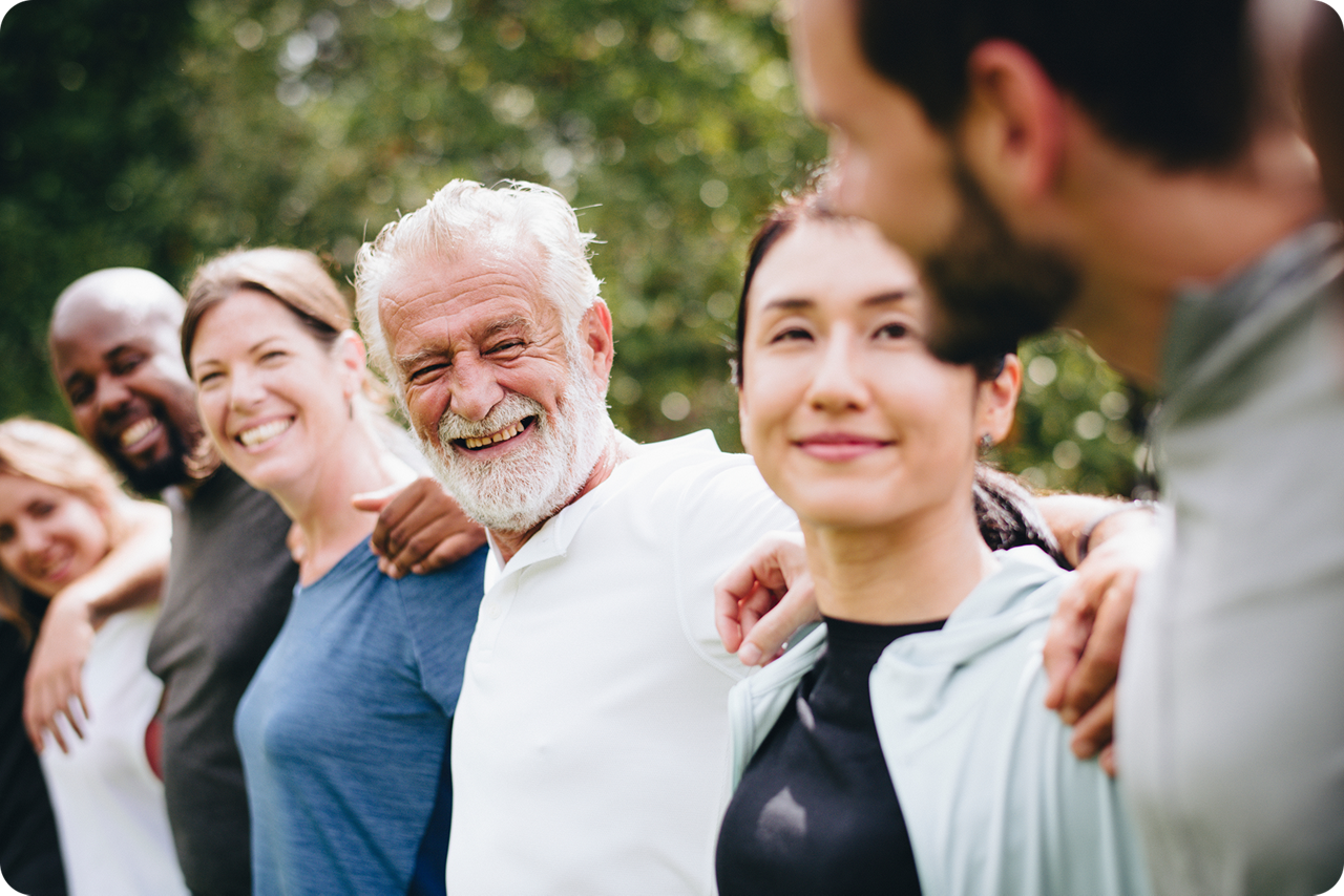 Viele Menschen stehen im Kreis und greifen sich an der Schulter