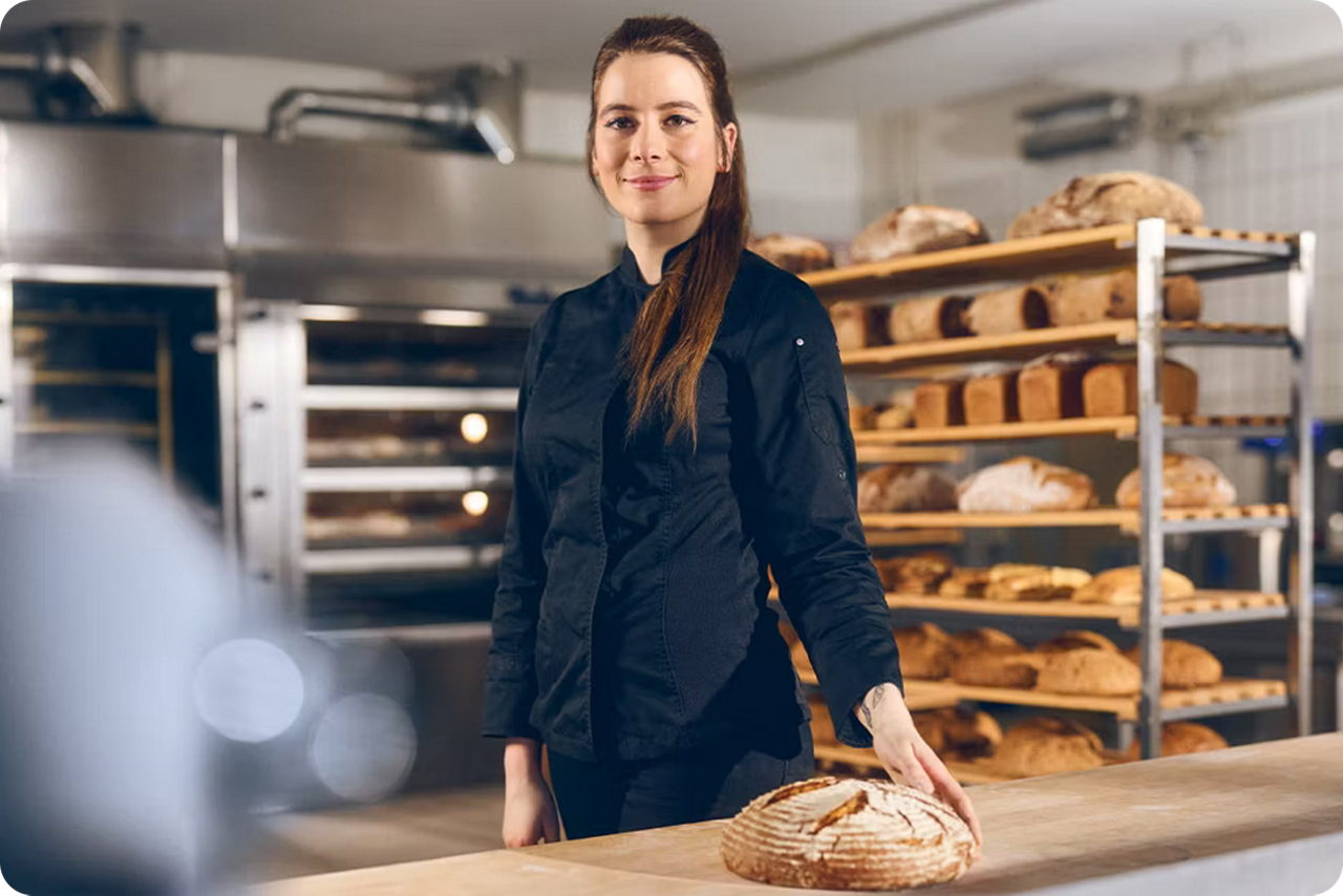 Eine Bäckerin steht in ihrer Backstube