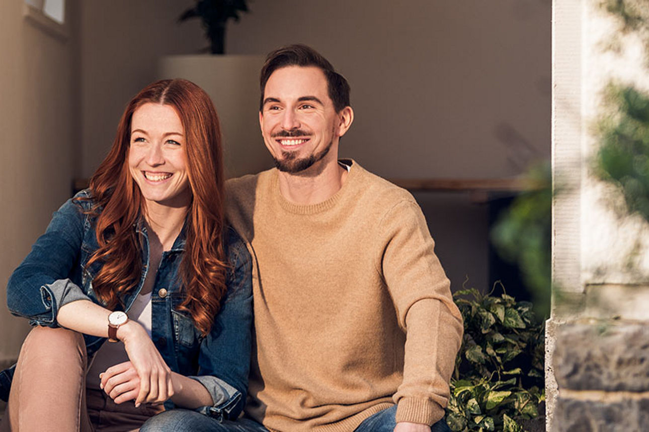 ein junges Paar sitzt auf einer Veranda