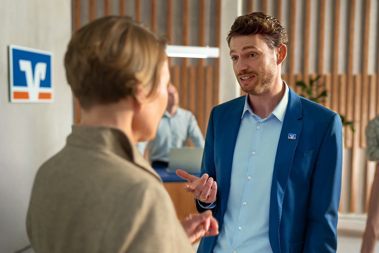 Ein Bankmitarbeiter ist im Gespräch mit einer Frau.