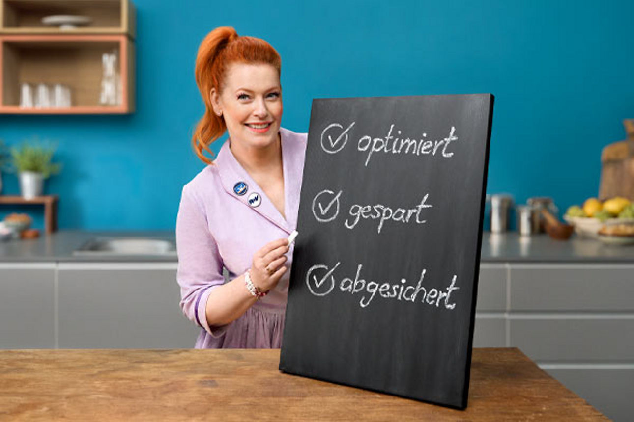 Enie van de Meiklokjes präsentiert die Vorteile des Versicherungs-Checks auf einer Kreidetafel