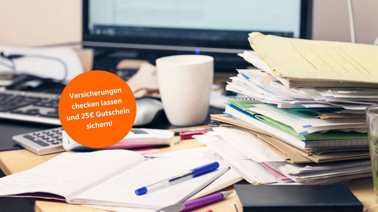 Stapel mit Ordnern und Blättern auf einem Schreibtisch
