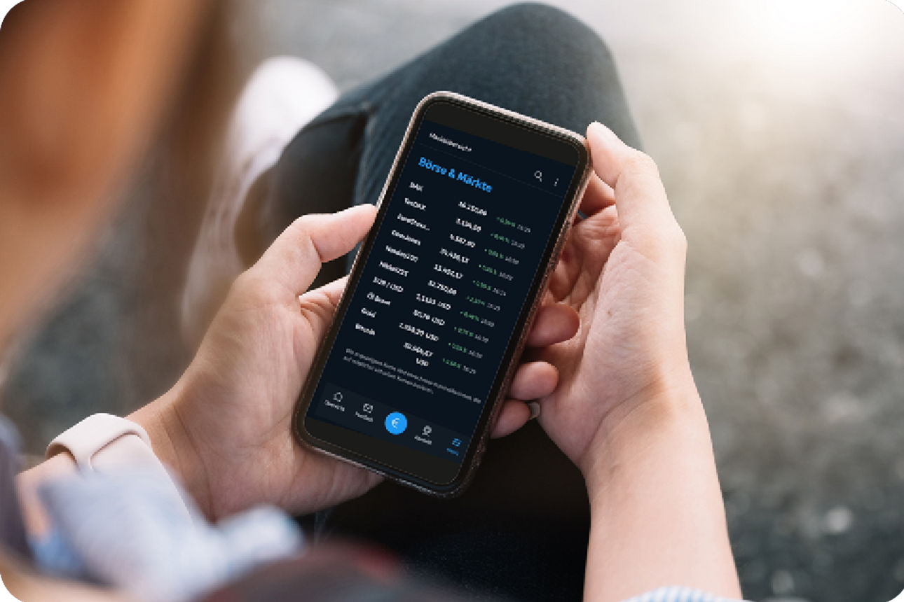 Ein Mann hält sein Handy mit der Banking App in der Hand und schaut sein Depot an.