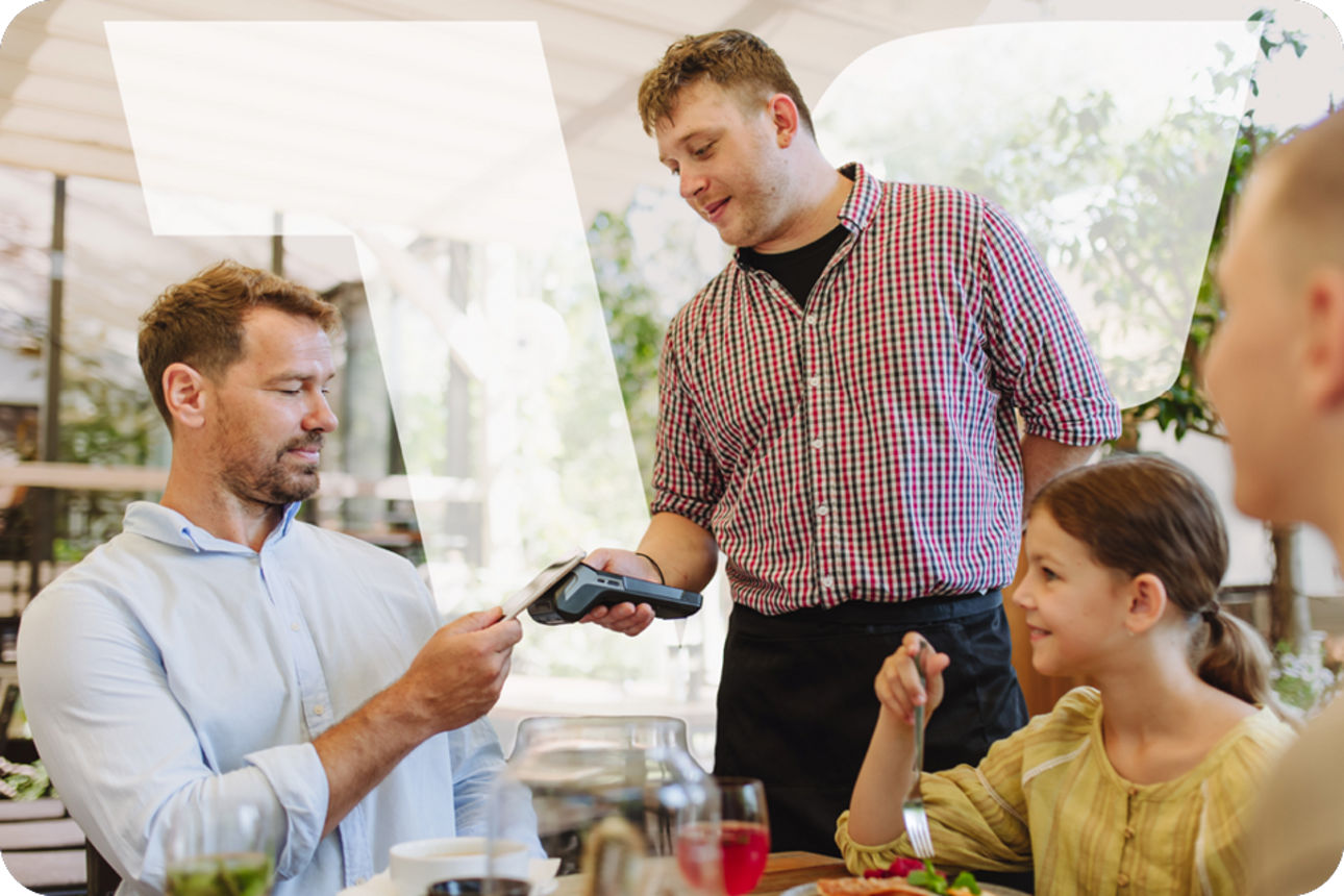 Vater zahlt im Restaurant mit Karte