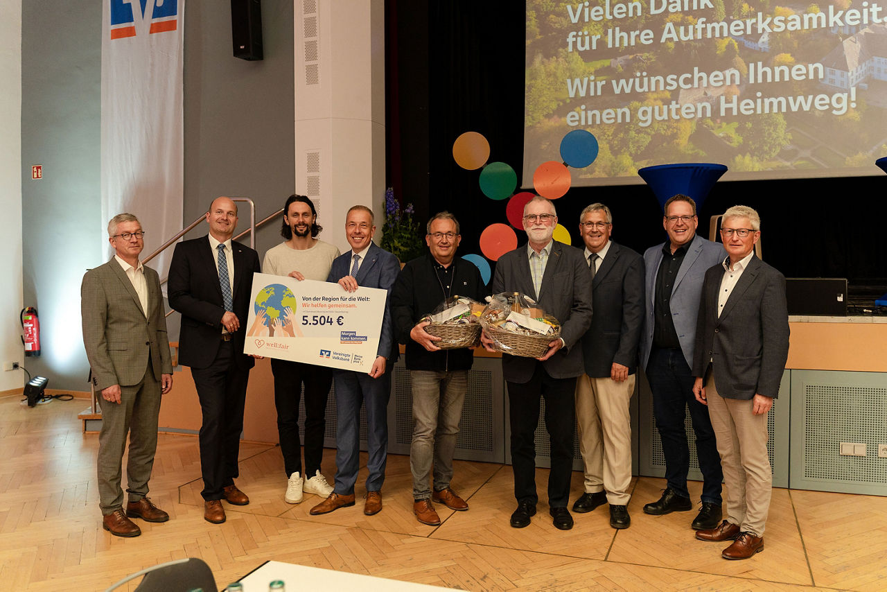 Eine Personengruppe stehen vor einer Bühne