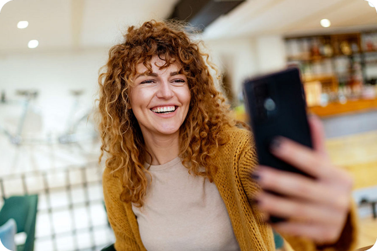 Frau lacht und schaut in ihr Smartphone