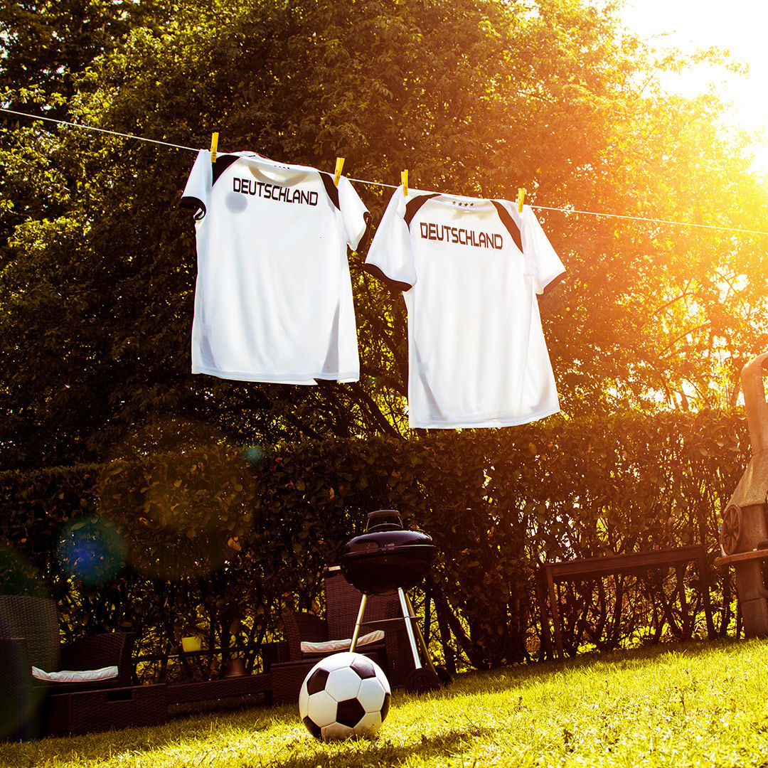 Zwei Fußballtrikots hängen an einer Wäscheleine.