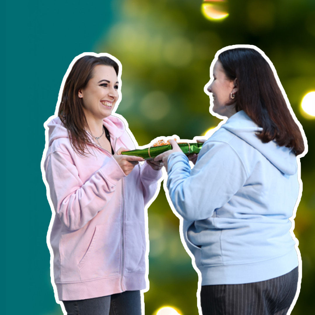 Eine Frau überreicht einer anderen Frau ein Geschenk