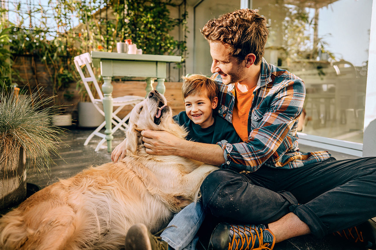 Mann mit Kind und Hund im Arm