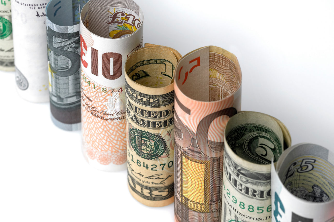 Verschiedene Währung als Gelscheine in sich gerollt