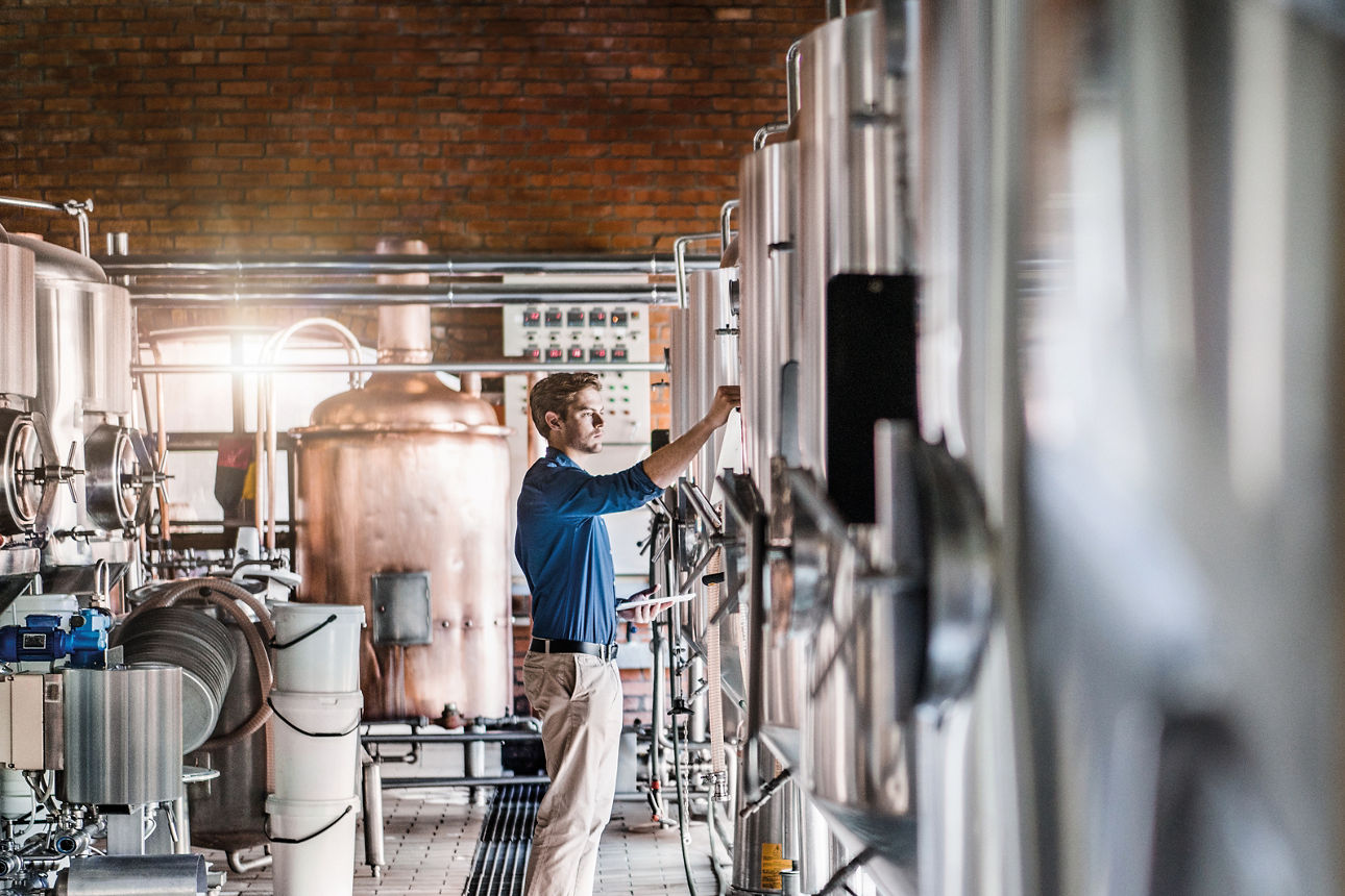 Junger Mann guckt sich Pläne in einen Maschienenraum an
