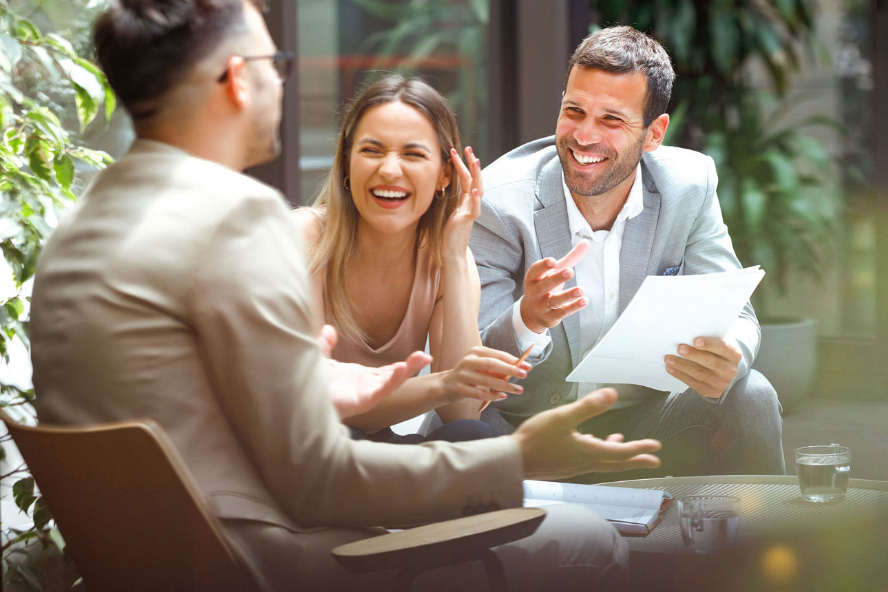 Drei Personen sitzen zusammen und besprechen sich. 