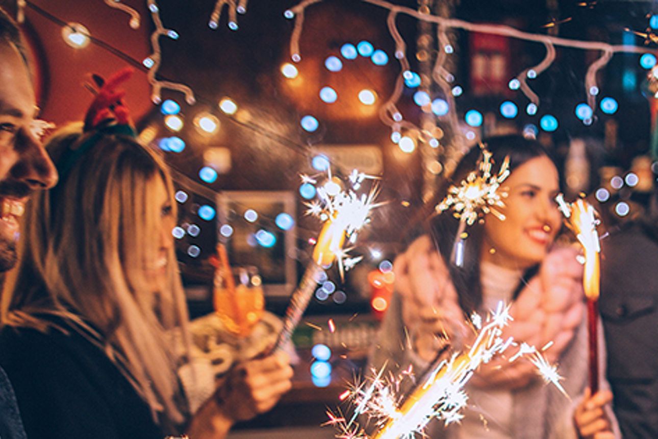Personen mit Wunderkerzen in der Hand und feiern Silvester