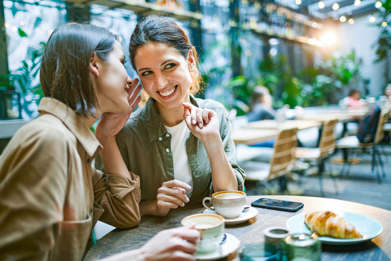 Zwei Frauen sitzen im Cafe und reden