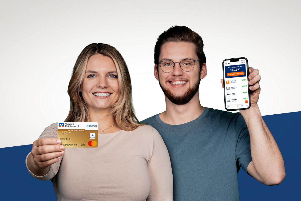 Mitarbeiter der Volksbank Mittelhessen zeigen mit Ihrer Hand ein Telefon