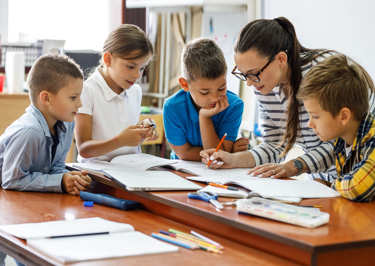 Lehrerin und Schüler korrigieren arbeiten