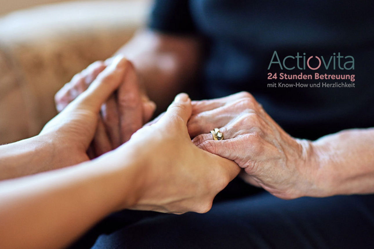 Frau hält die Hände einer älteren Dame