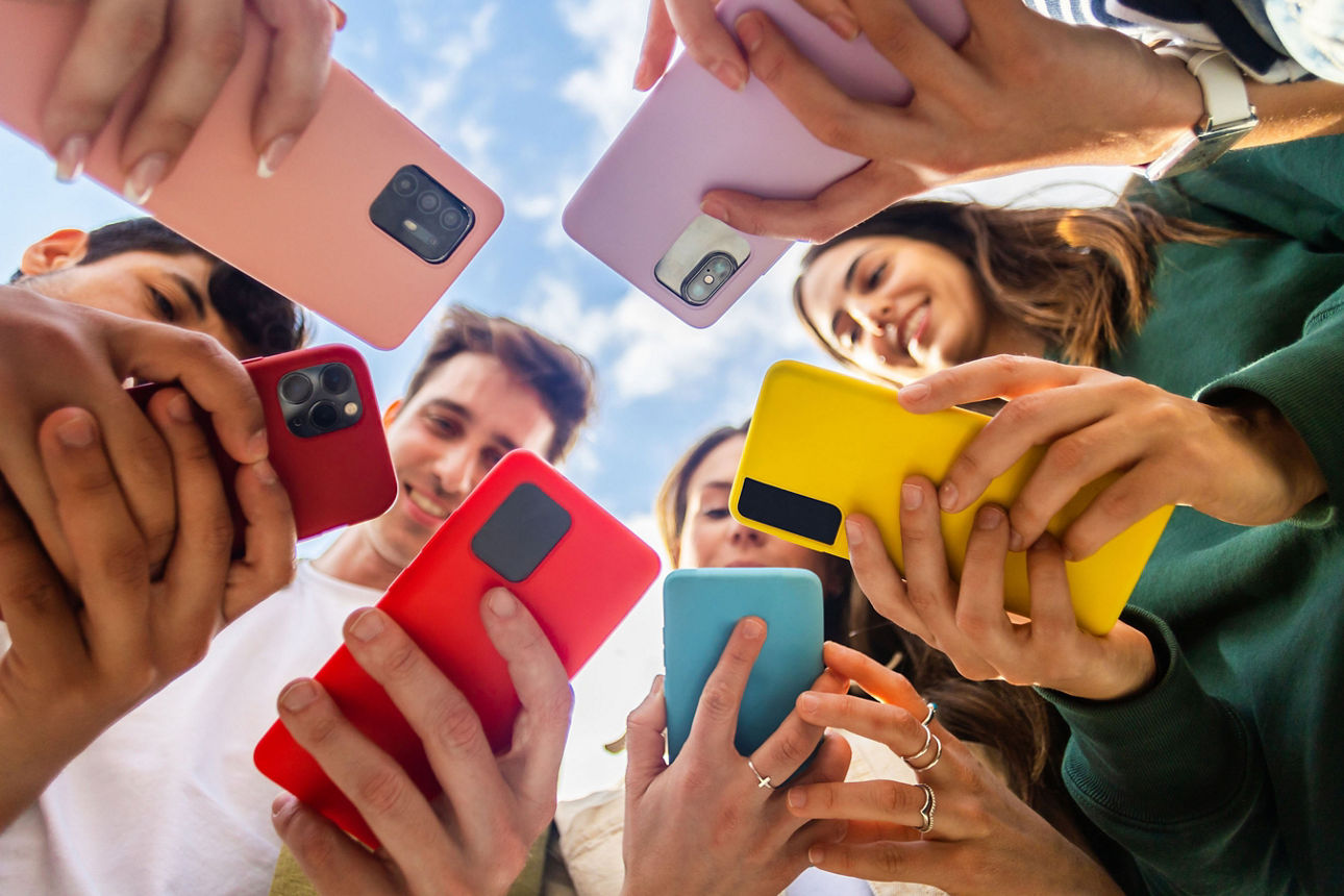 Junge Gruppe ist draußen am Handy 