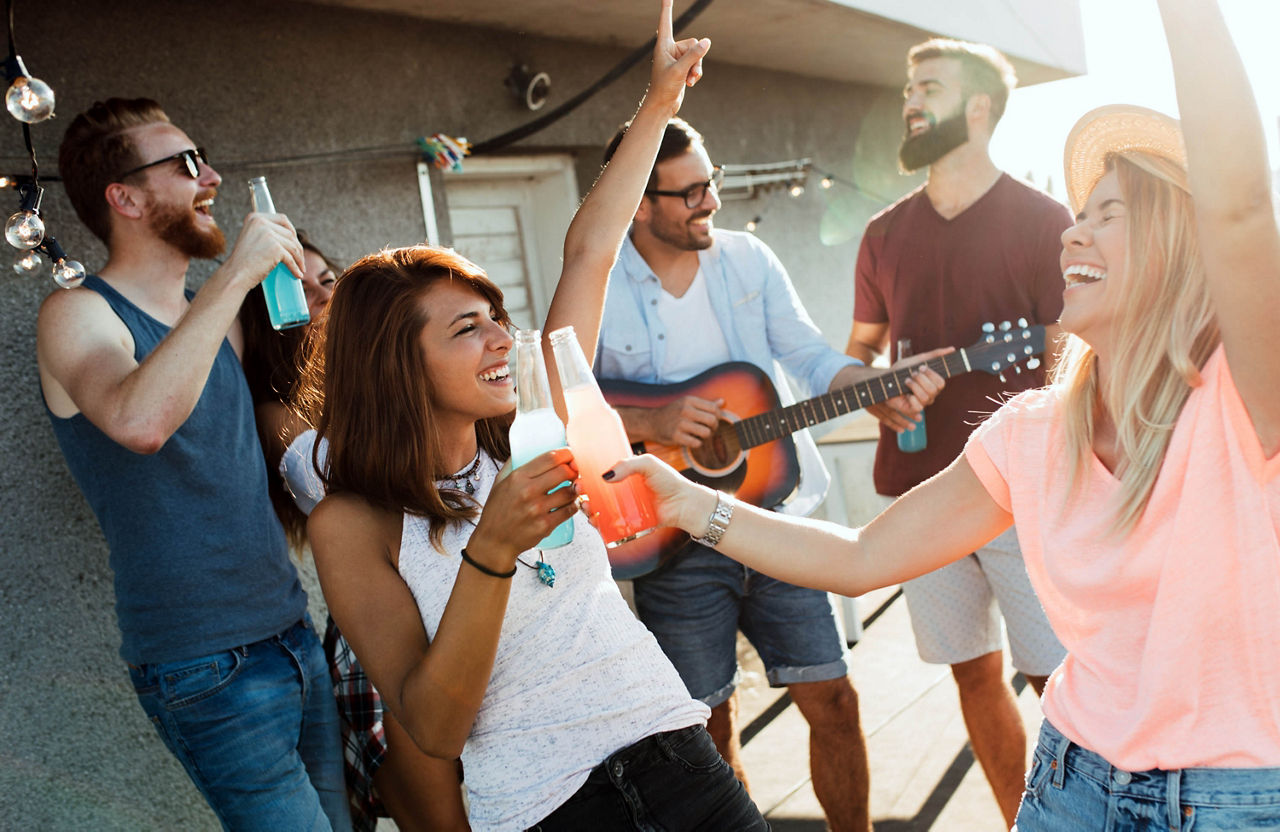 Eine Gruppe glücklicher Freunde feiert eine Party auf dem Dach