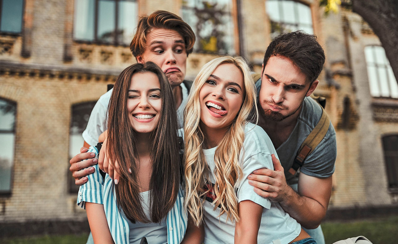 Eine Gruppe junger Leute studiert gemeinsam an der Universität. Studenten im Freien haben Spaß.