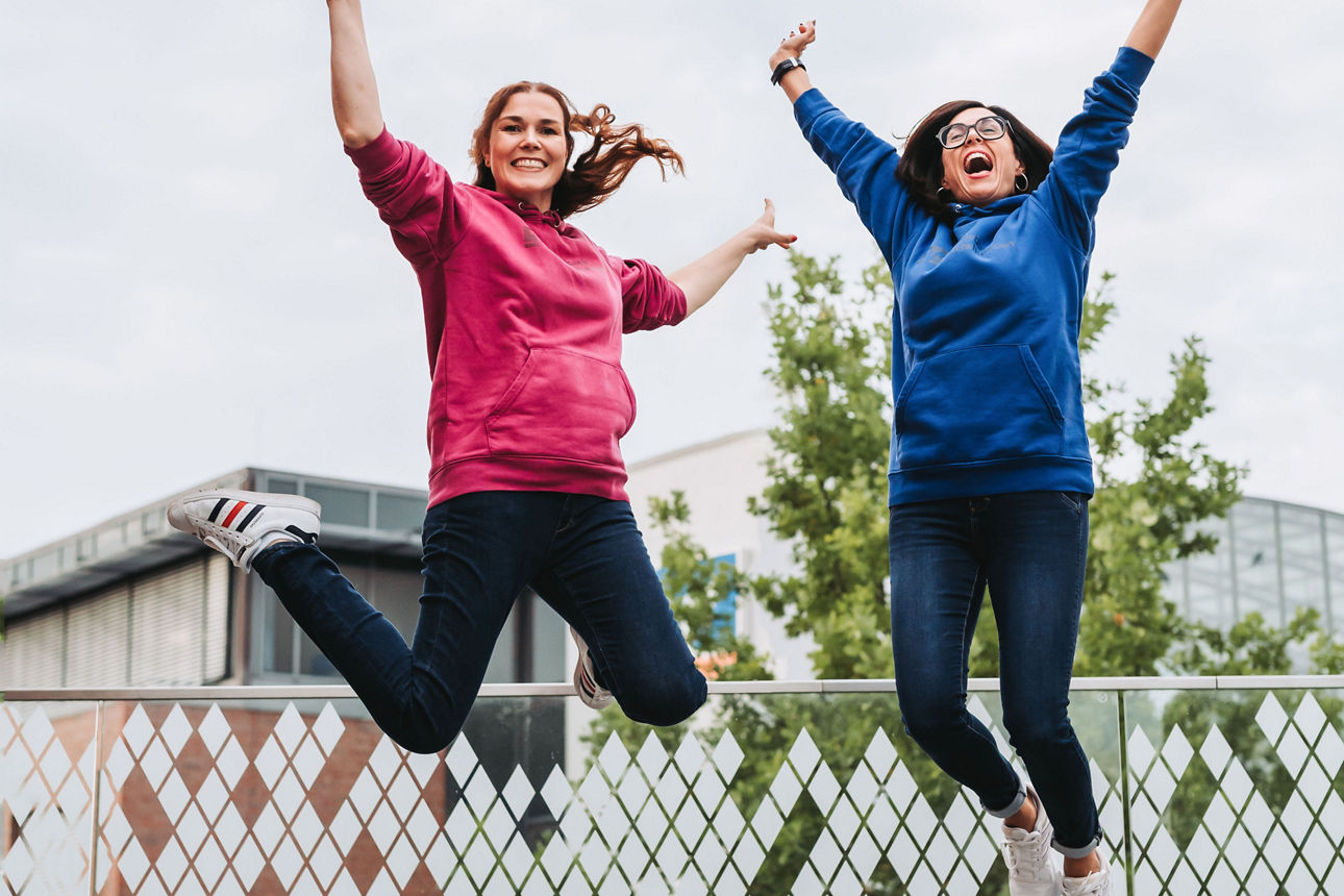 Zwei Frauen springen freudig in die Luft