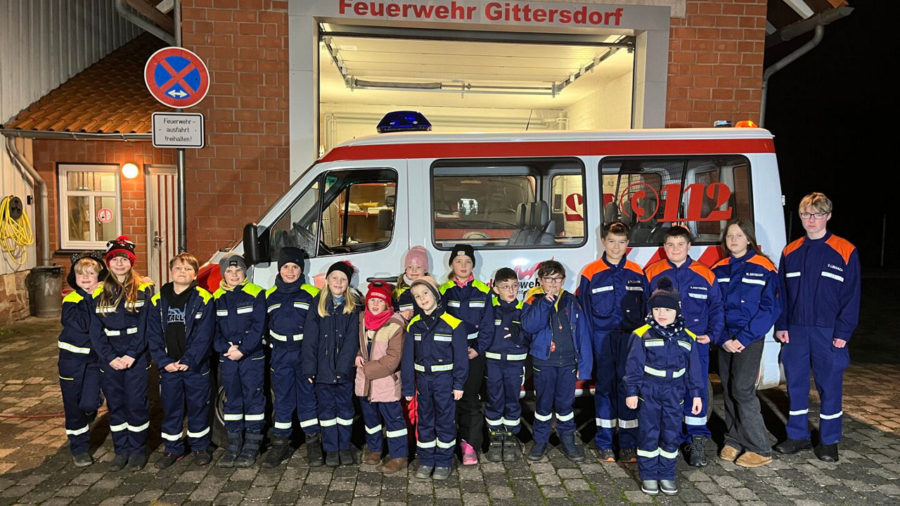 Kinder der Freiwilligen Feuerwehr stehen vor einem Feuerwehrauto