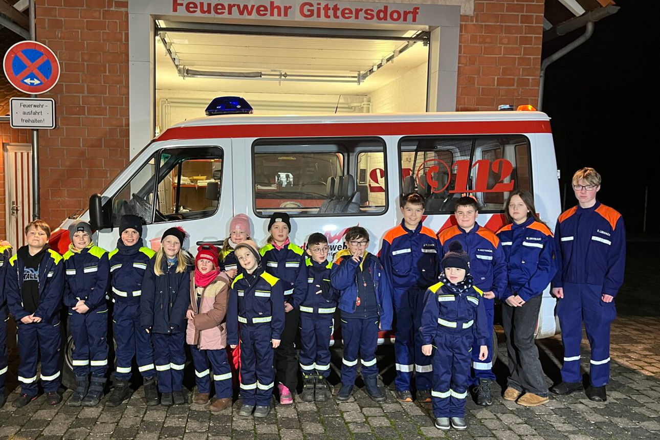 Kinder der Freiwilligen Feuerwehr stehen vor einem Feuerwehrauto