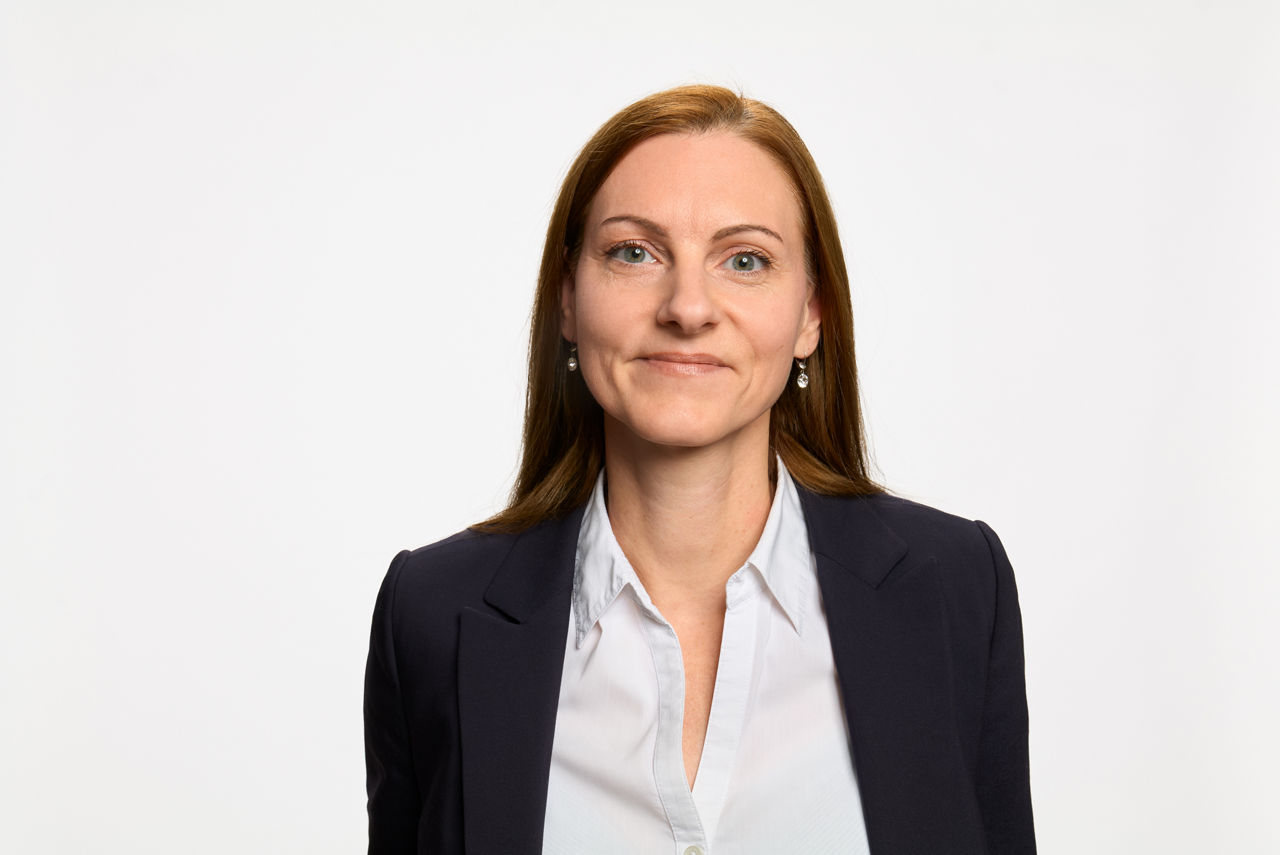 Firmenkundenberaterin Sabrina von Mirbach vor grauem Hintergrund
