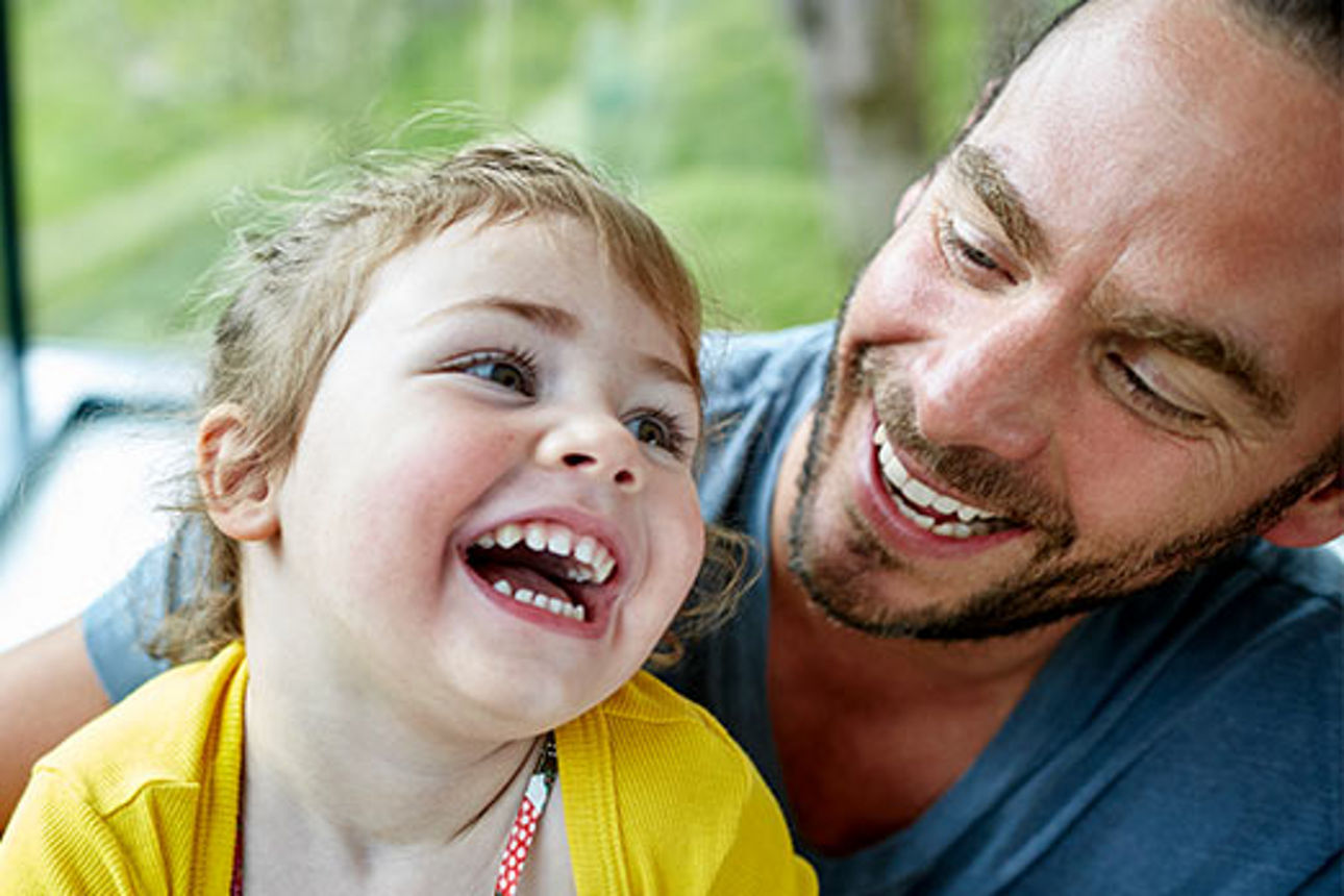 Ein Mann und ein Kleinkind lachen sich an