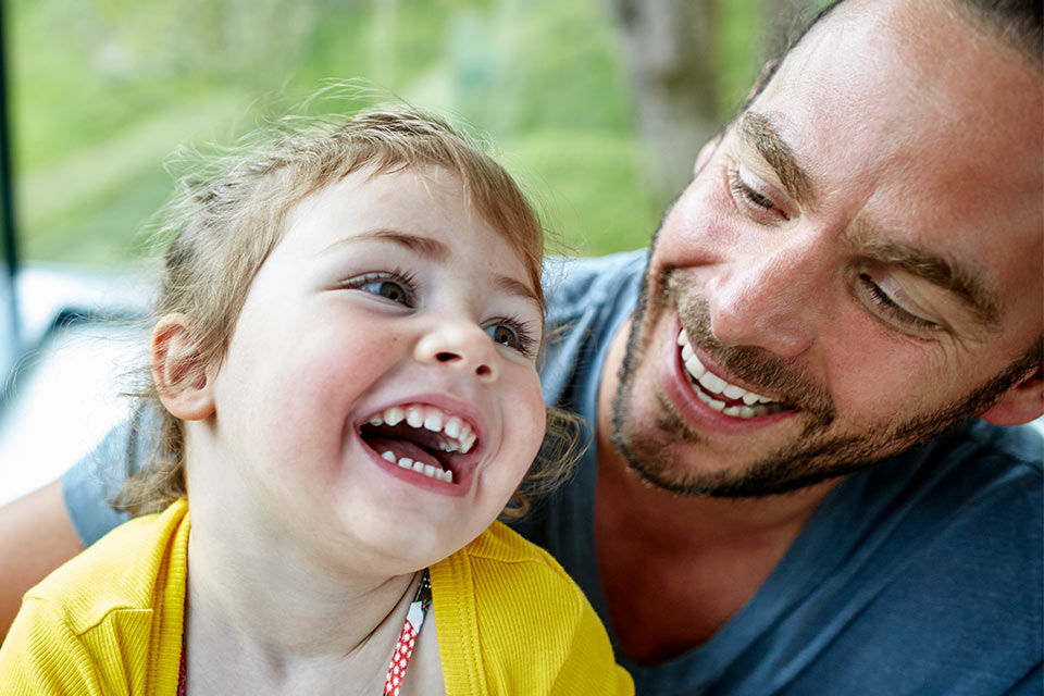 Ein Mann und ein Kleinkind lachen sich an