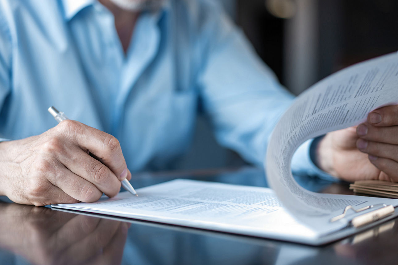 Mann unterzeichnet ein Dokument.