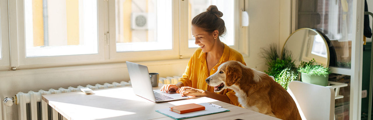 Junge Frau mit Hund vor dem Laptop