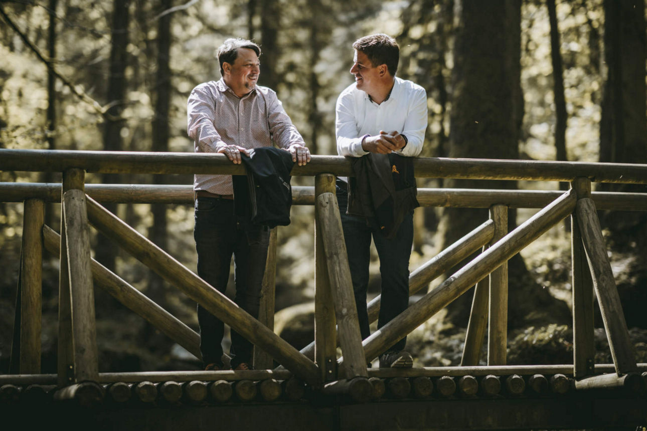 Vorstände Marco Feit und Hans-Jörg Meier stehen auf einer Brücke im Wald