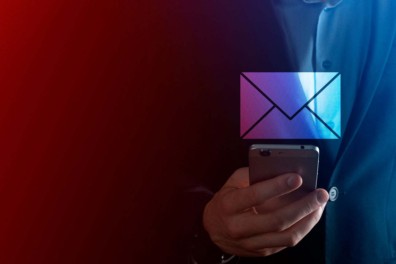 Ein Mann im Anzug hält ein Smartphone in der Hand, über dem ein digitales Umschlagsymbol schwebt