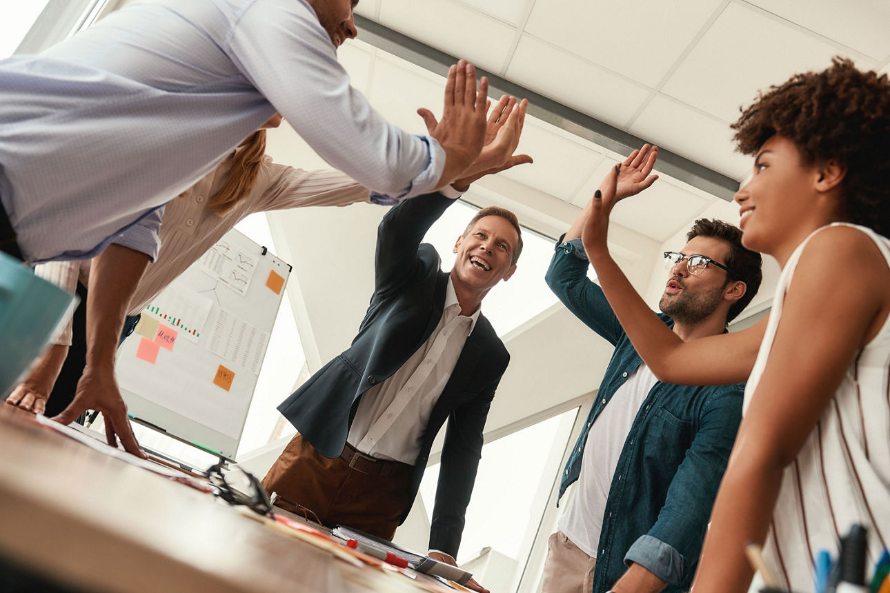 Erfolgreiche Businessleute geben sich lächelnd ein Hiigh-Five