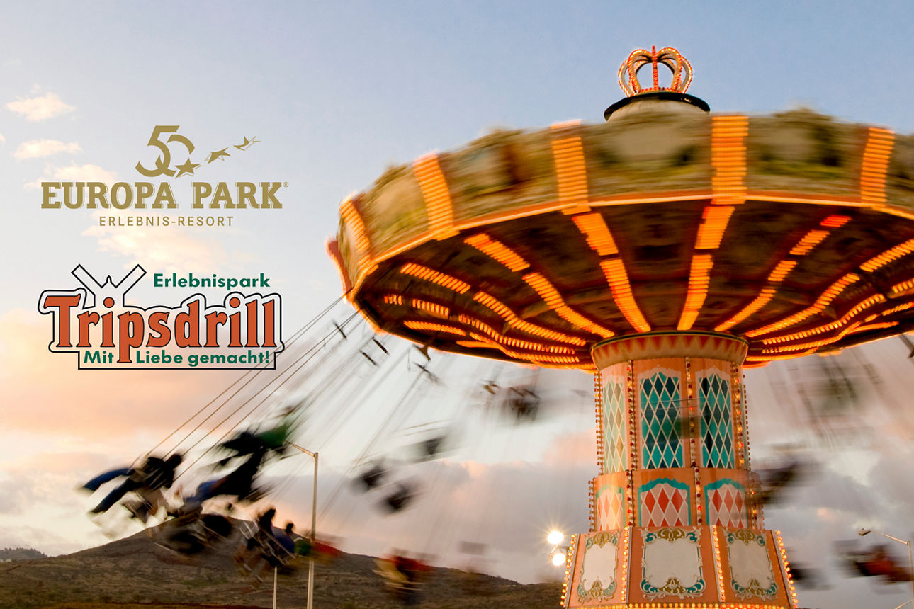 Beleuchtetes Kettenkarussell in Bewegung vor Abendhimmel, daneben Logos von Europa-Park und Erlebnispark Tripsdrill.