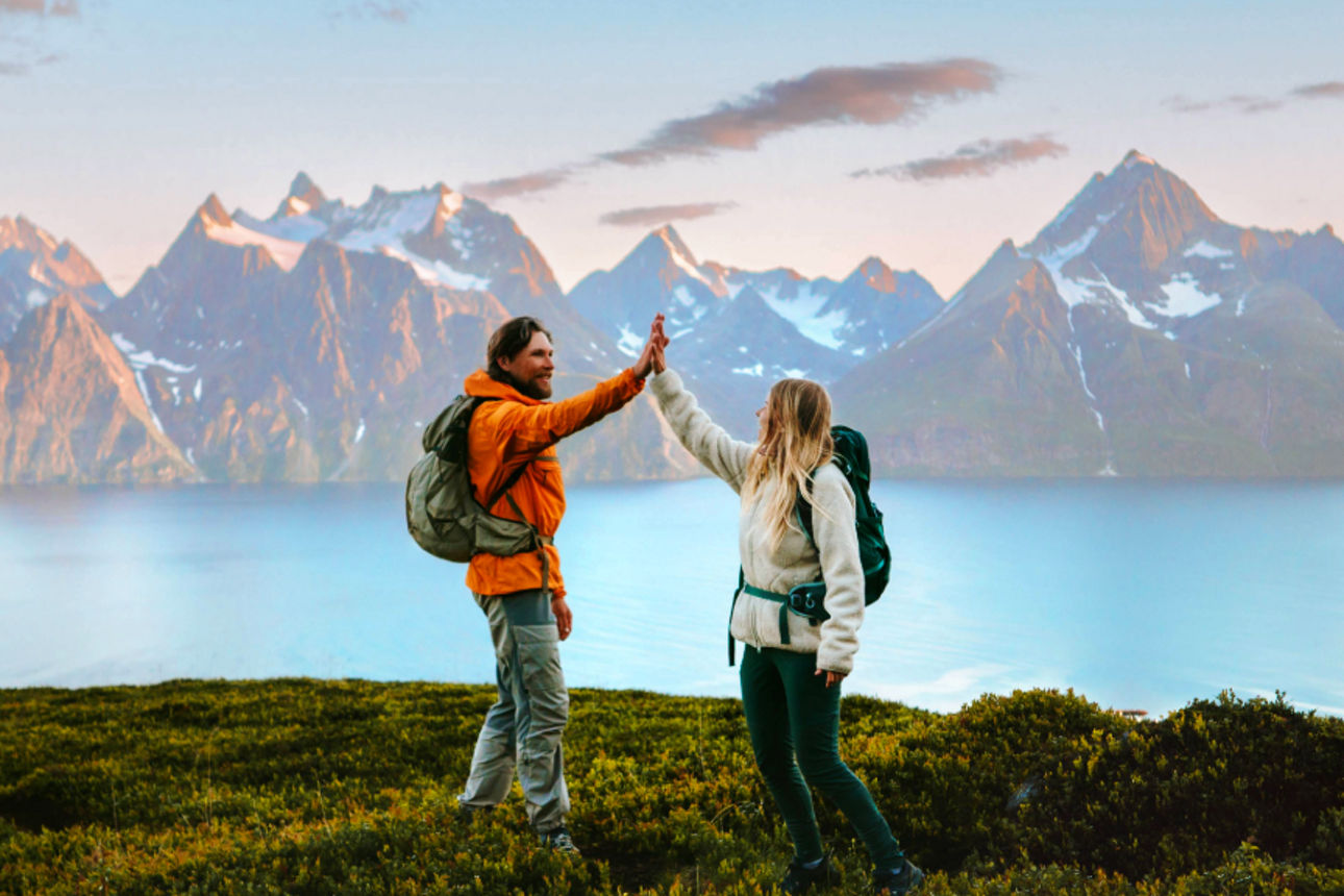 Mann und Frau stehen auf einem Hügel mit schöner Aussicht