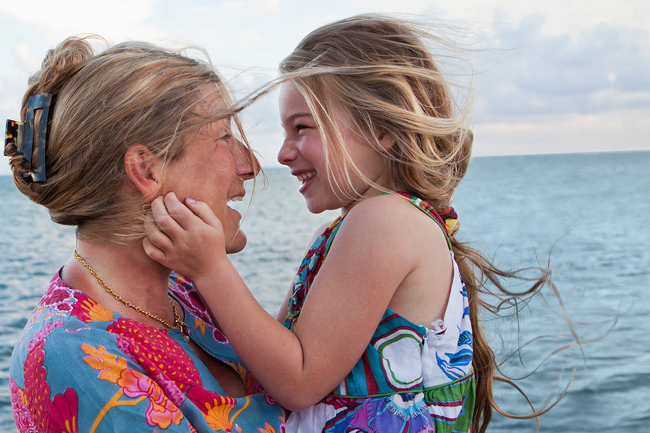 Oma und Enkeltochter stehen fröhlich am Meer
