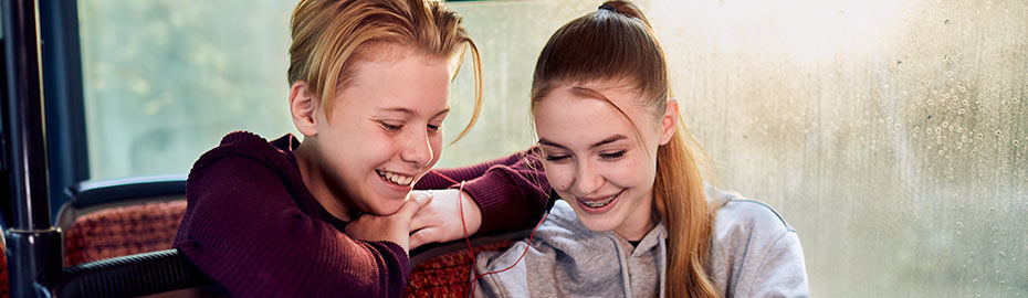 Zwei junge Teenager sitzen in einem Auto, unterhalten sich und genießen die Gesellschaft des jeweils anderen.