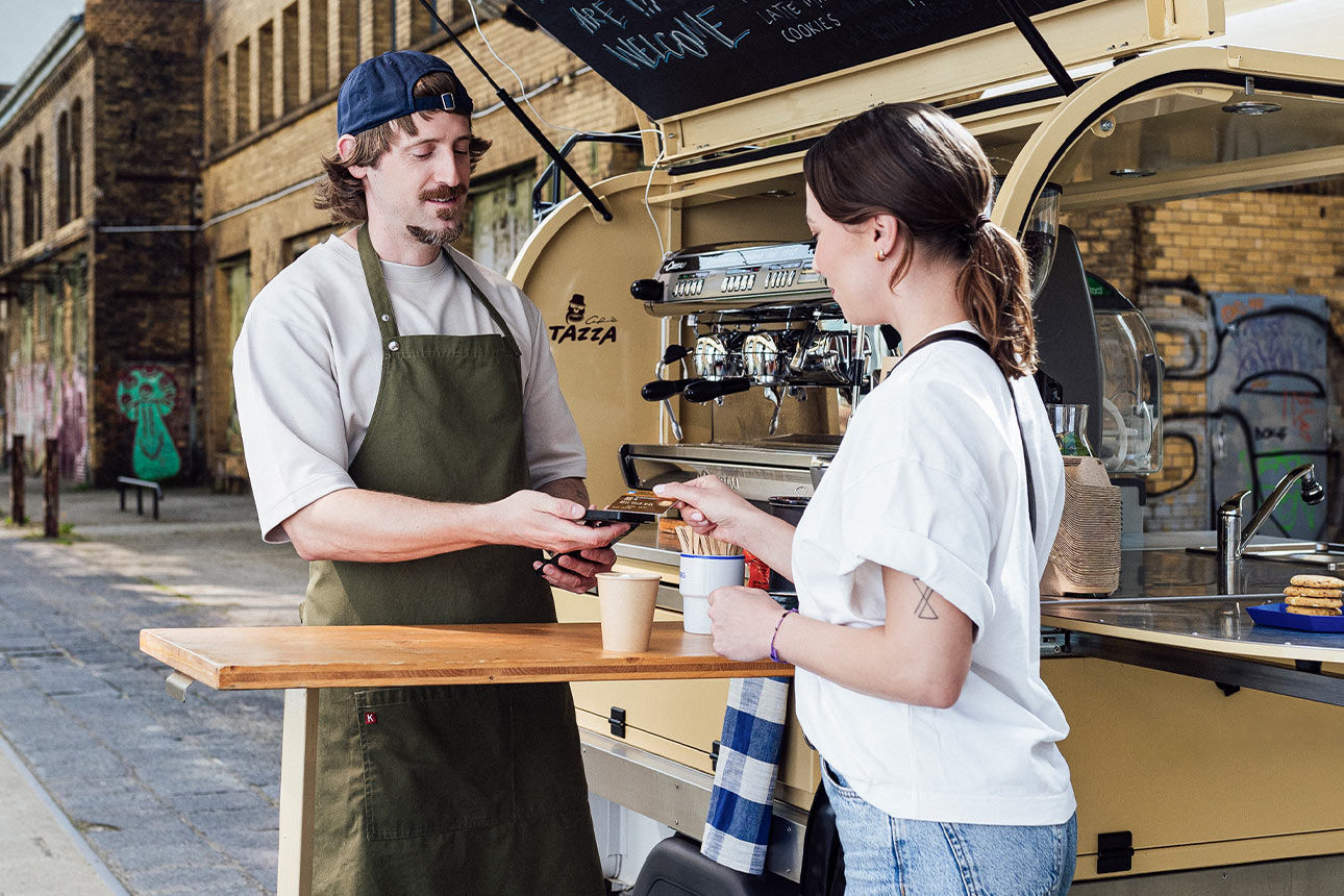 Frau bezahlt Kaffee mit Karte