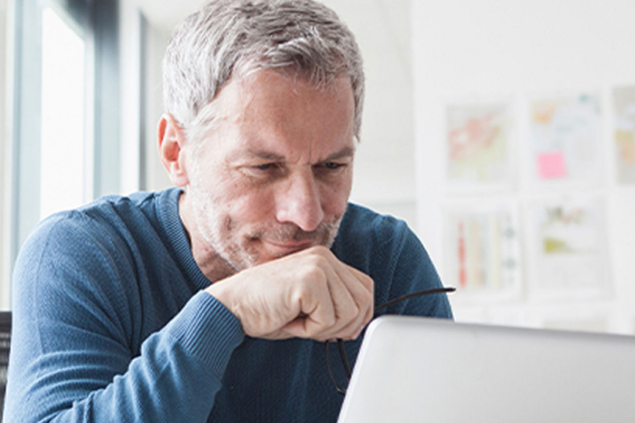 Börseninformationen - Mann sitzt vor seinem Laptop