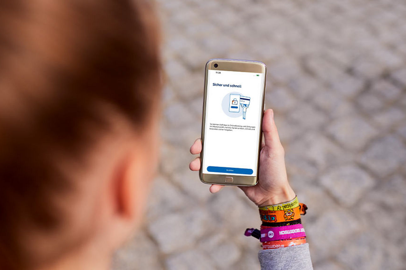 Wir schauen einer Frau über die Schulter, die auf ihr Handy schaut.