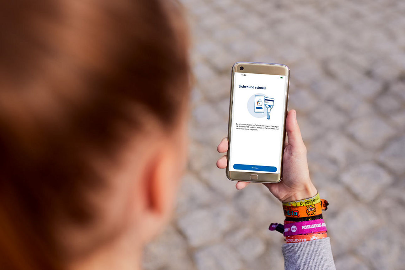 Frau mit einem Smartphone in der Hand, auf der die VR SecureGo plus App geöffnet ist