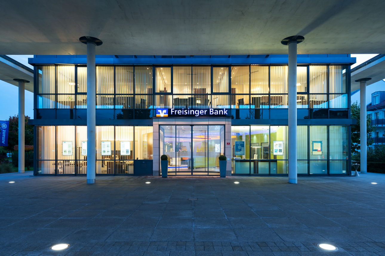 Weitwinkelaufnahme des Eingangs der Freisinger Bank fotografiert in der Blauen Stunde