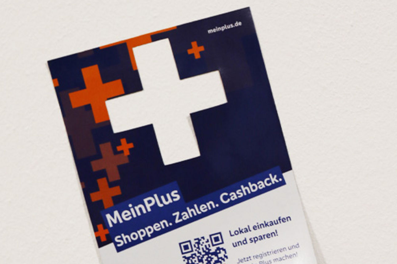 MeinPlus Regio+ - Werbemittel Aufkleber mit einem großen weißen Plus-Zeichen vor blauem Hintergrund und einem QR-Code