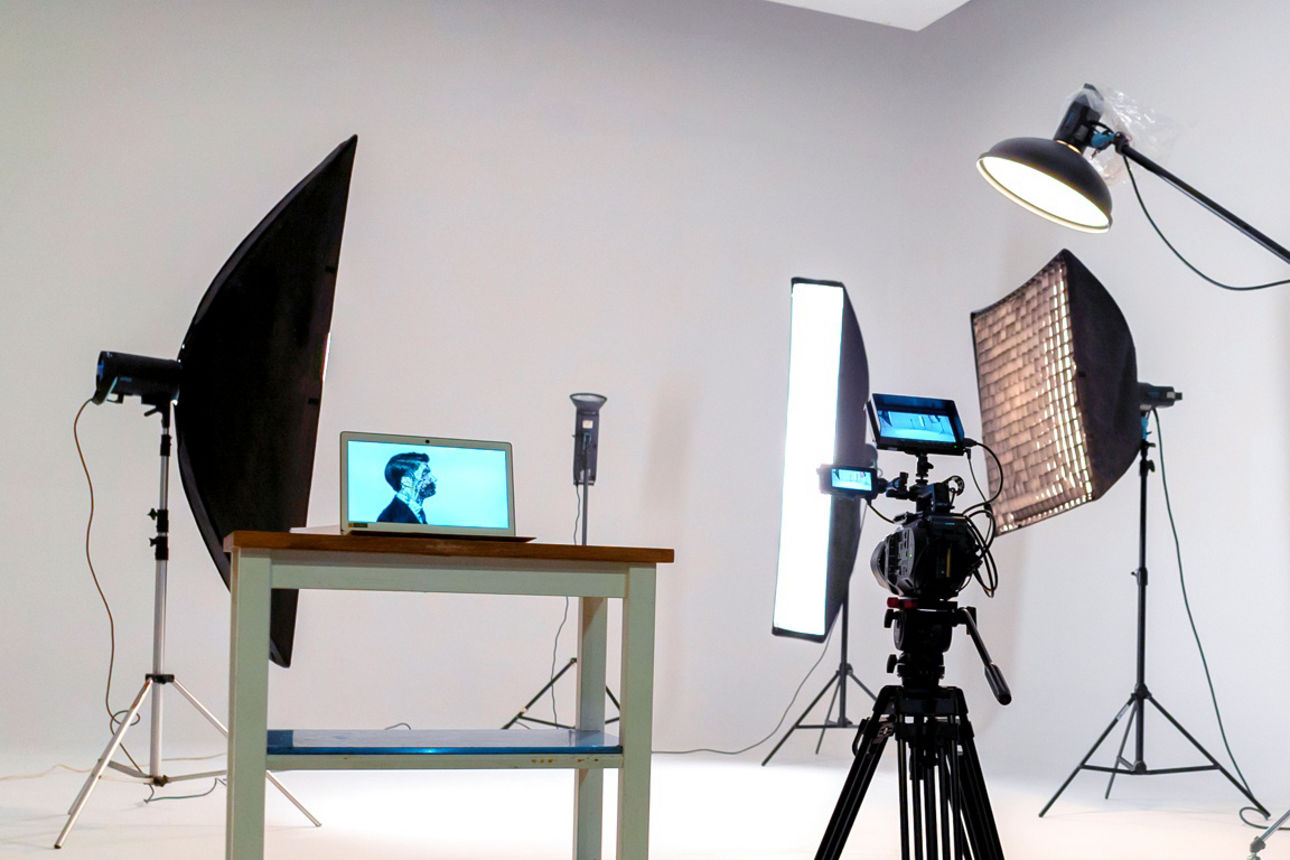 Aufbau eines Fotostudios mit Kamera, Leuchten und Kontrollmonitor